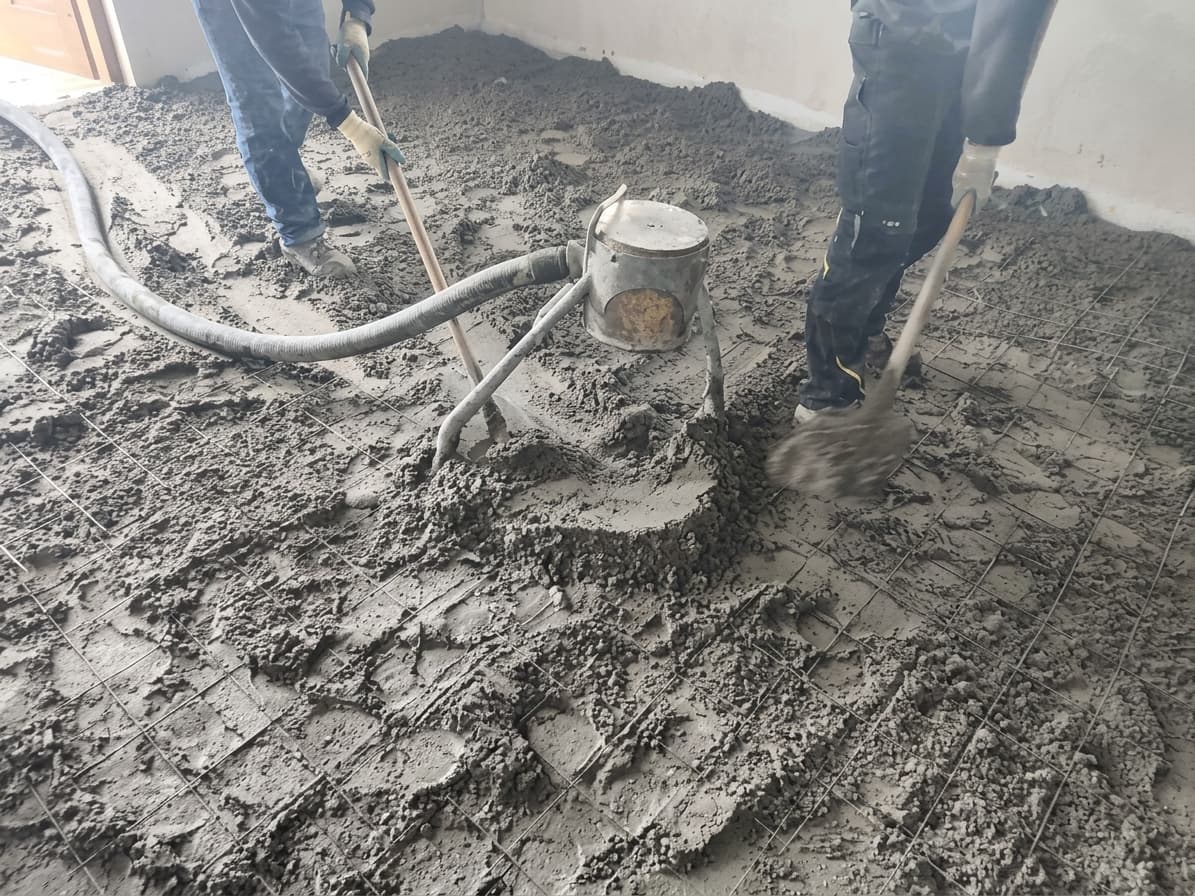 Rozprowadzanie półsuchej mieszanki podawanej wężem na zbrojonej podłodze